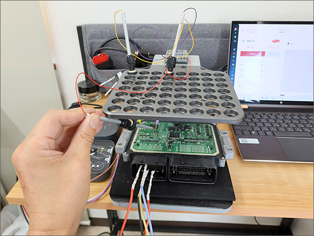 治具にセットしたプローブをECU基板へ接触させる作業